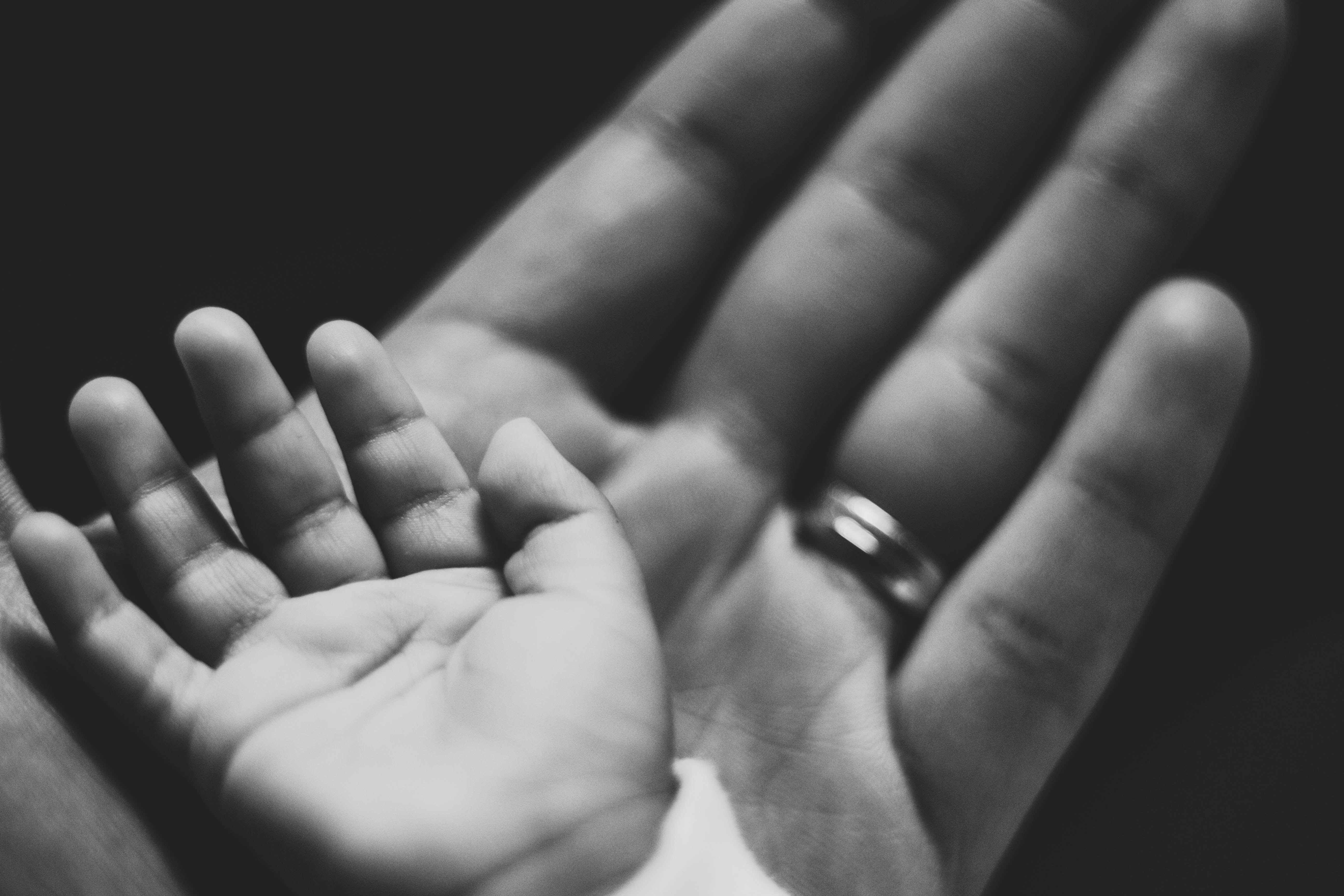 A child's hand resting on a father's hand