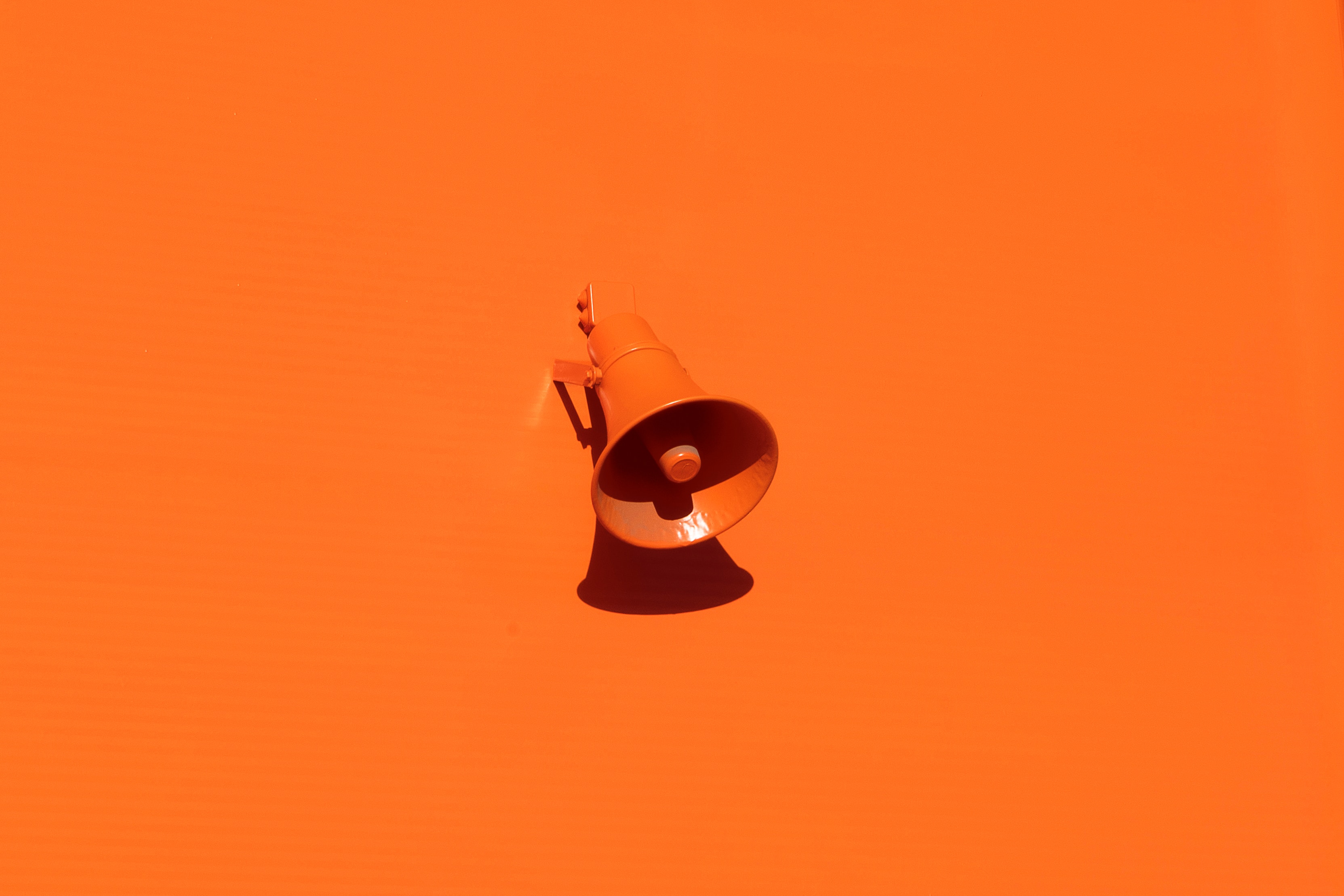 Orange megaphone sitting on orange background