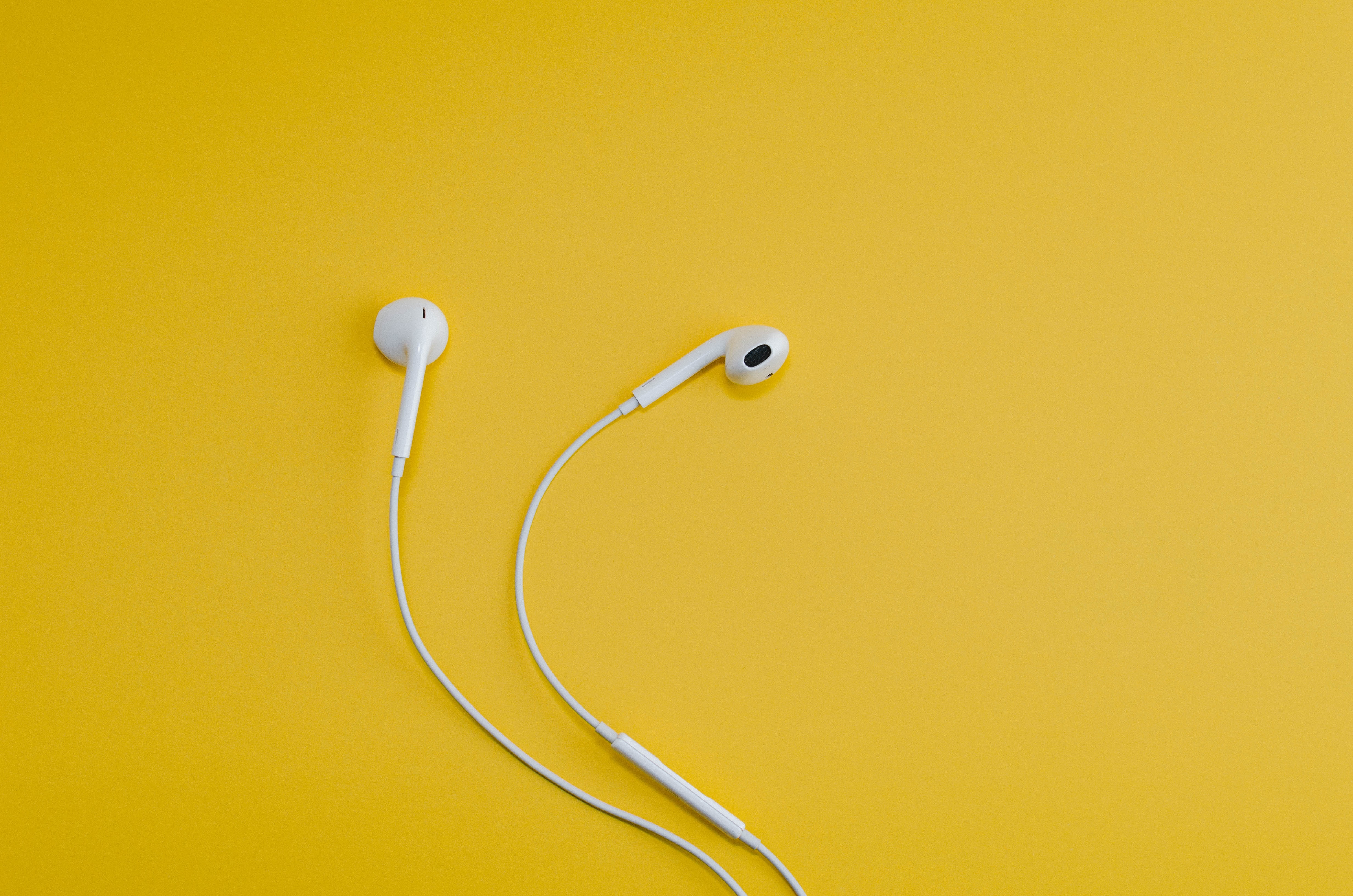White earbuds on a yellow background